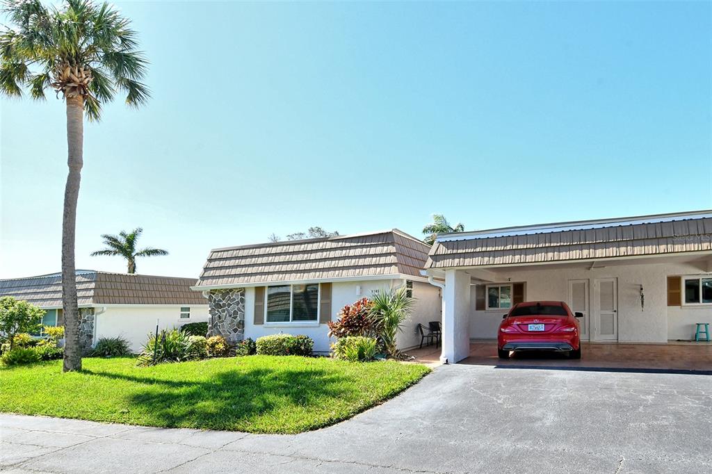 A single-story house with a stone facade, a carport, and a red car parked outside — 2607 RIVERBLUFF PARKWAY UNIT V145, SARASOTA, FL