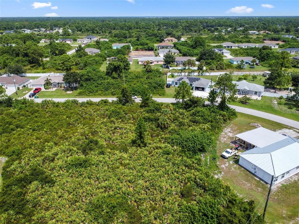 An aerial view shows a vacant, brush-covered lot situated in a residential neighborhood — 12447 BIRTLE AVENUE, PORT CHARLOTTE, FL