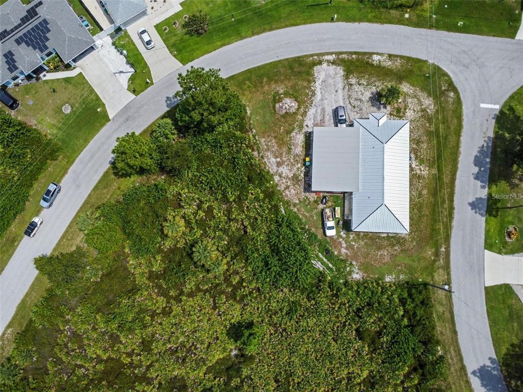 An aerial view shows a house with a metal roof on a corner lot — 12447 BIRTLE AVENUE, PORT CHARLOTTE, FL