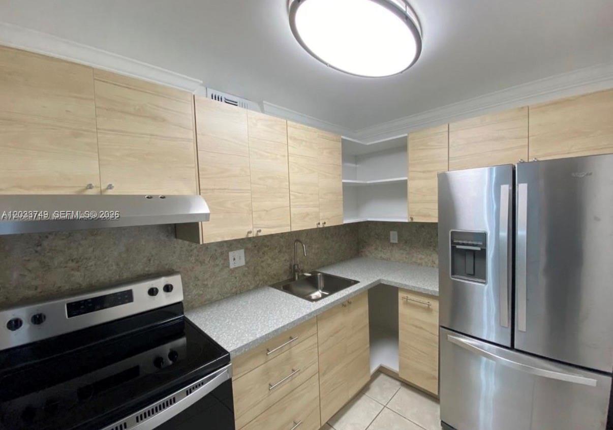 A kitchen features light wood cabinets, stainless steel appliances, and speckled gray countertops — 8421 NW 8th St # 203, Miami FL 33126, MIAMI, FL