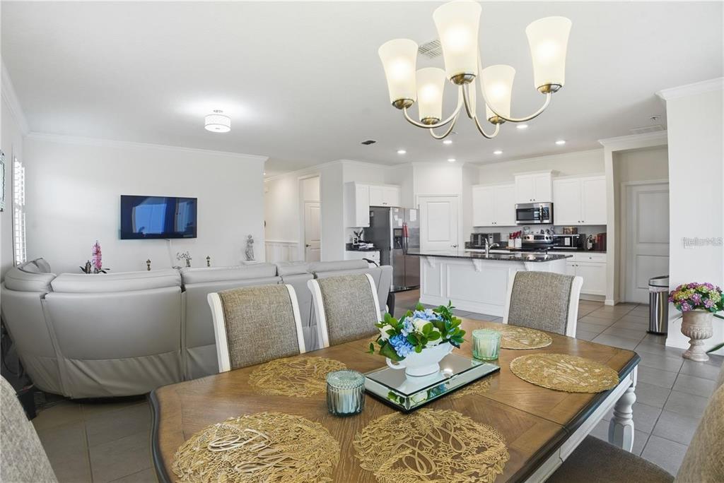 A dining area with a wooden table sits in front of an open-concept kitchen — 9152 SW 60TH COURT ROAD, OCALA, FL