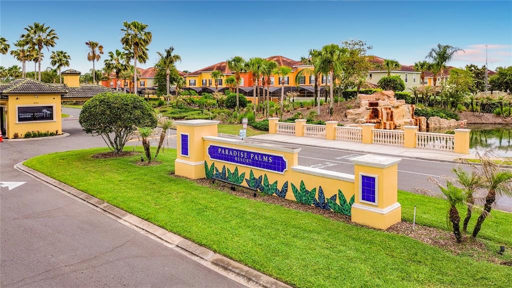The entrance to Paradise Palms Resort features a yellow monument sign and a stone waterfall — 8951 CALIFORNIA PALM ROAD, KISSIMMEE, FL
