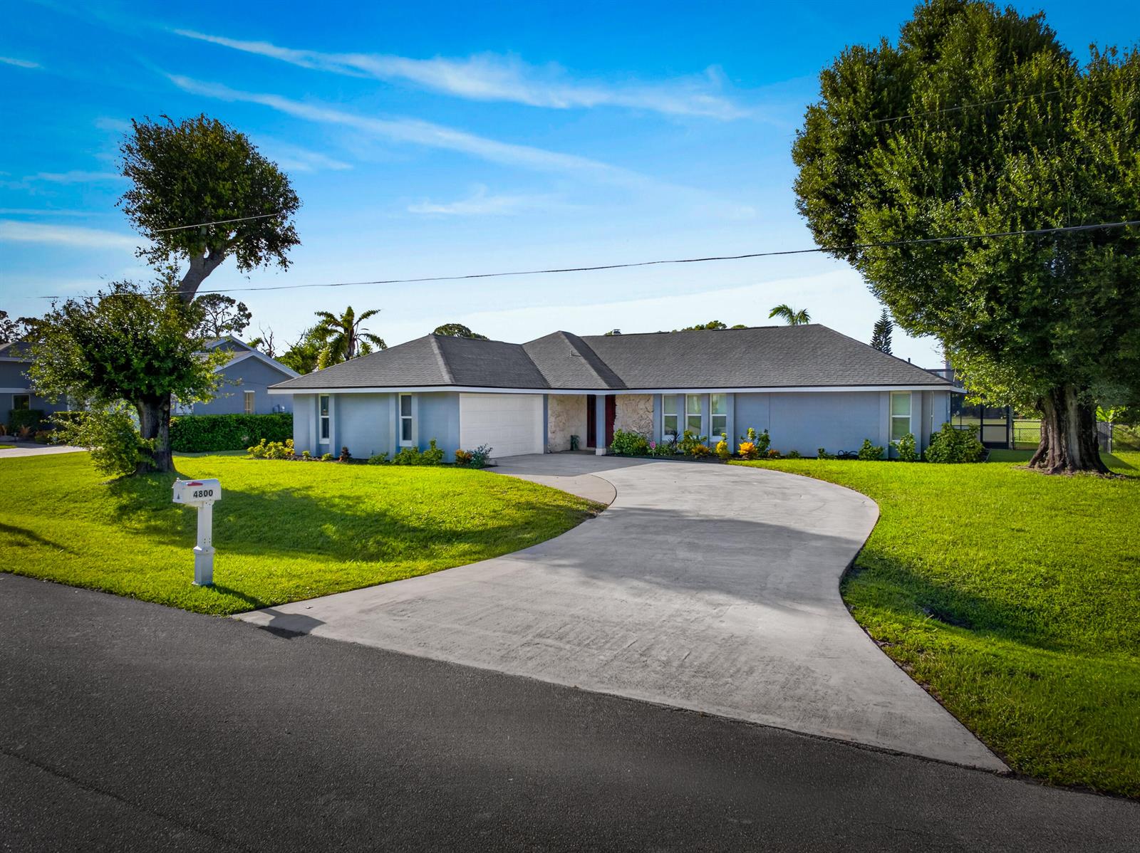 A single-story house with a gray exterior, a curved driveway, and large trees — 4800 Eagle Drive, Fort Pierce FL 34951, FORT PIERCE, FL