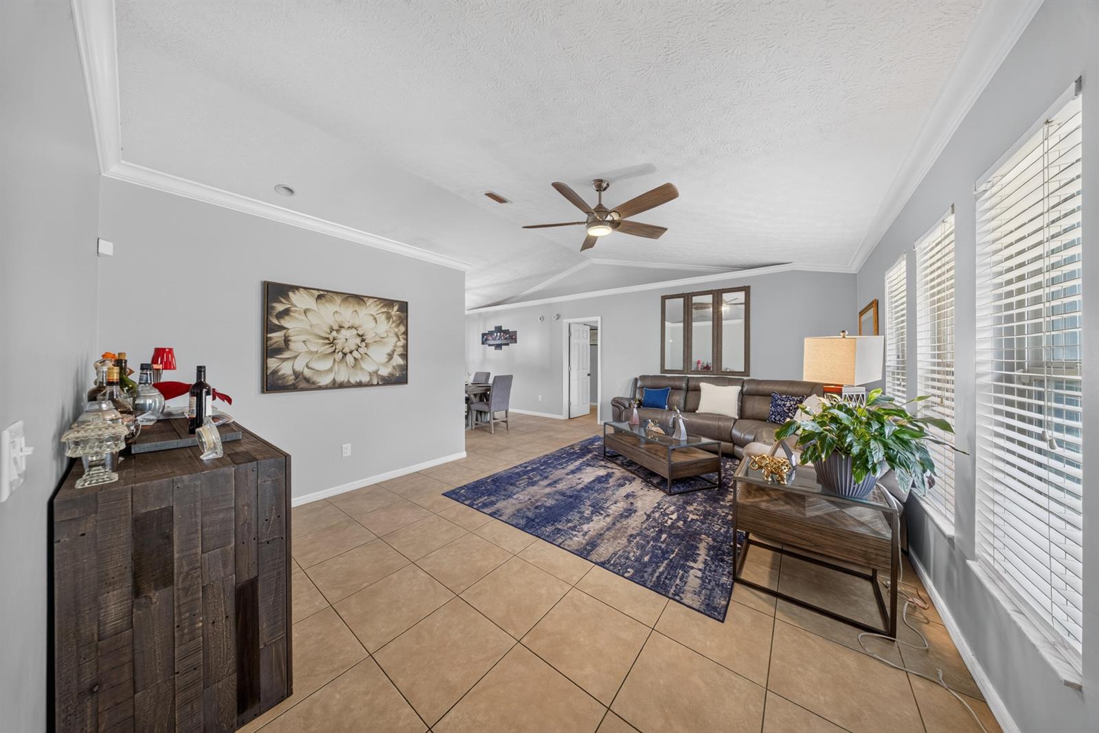 A living room features tile flooring, a blue area rug, a sectional sofa, and a bar — 4800 Eagle Drive, Fort Pierce FL 34951, FORT PIERCE, FL