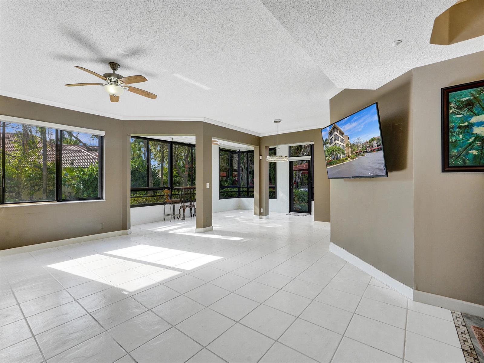 A spacious living area features white tile floors, a ceiling fan, and large windows — 7546 La Paz Boulevard # 108, Boca Raton FL 33433, BOCA RATON, FL