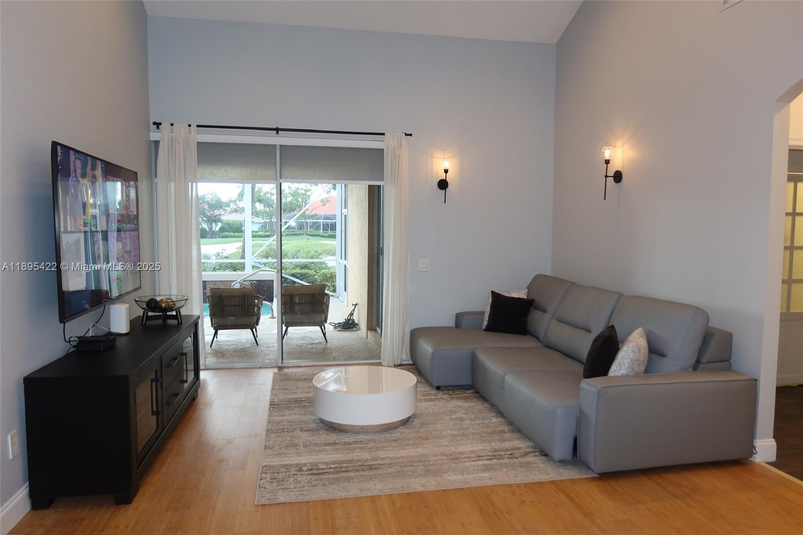 A living room features a gray sectional sofa, a white coffee table, and a television — 8189 Sandpiper Way, West Palm Beach FL 33412, WEST PALM BEACH, FL