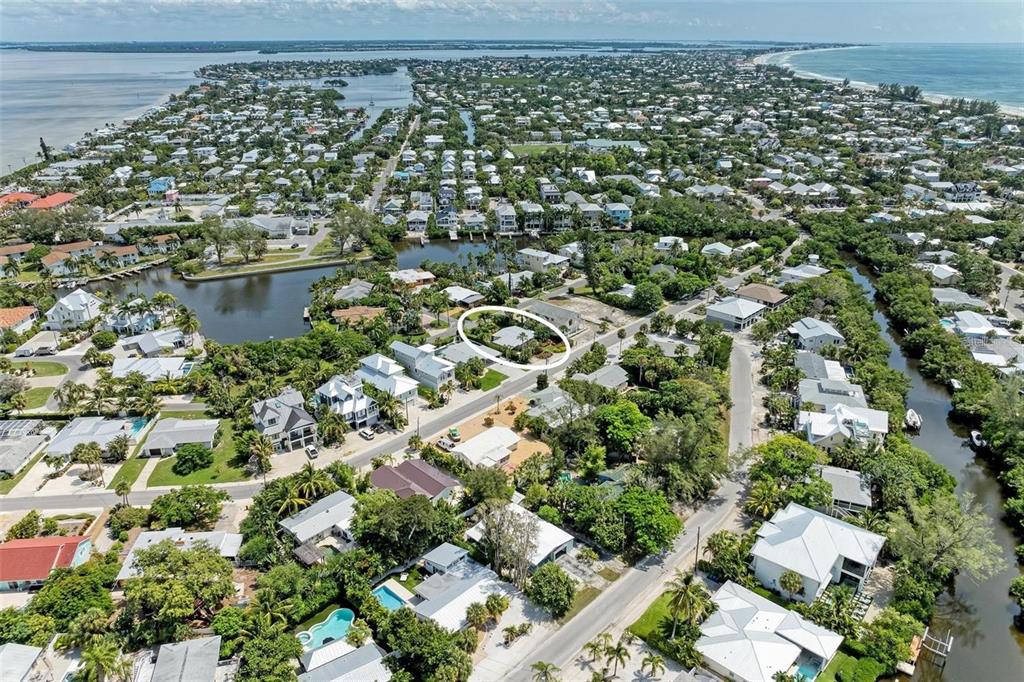 An aerial view shows a residential neighborhood with a circled house near a canal — 136 CRESCENT DR, ANNA MARIA, FL