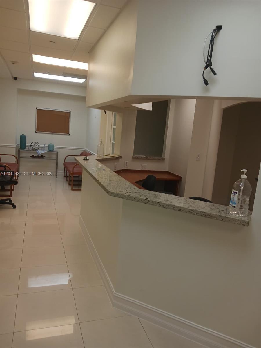 This office reception area features a granite-topped desk, tile flooring, and a waiting area — 13155 SW 42nd St # 112, Miami FL 33175, MIAMI, FL