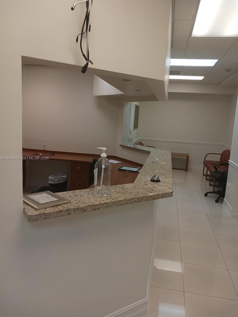 A reception area features a granite-topped desk, tile flooring, and a drop ceiling — 13155 SW 42nd St # 112, Miami FL 33175, MIAMI, FL