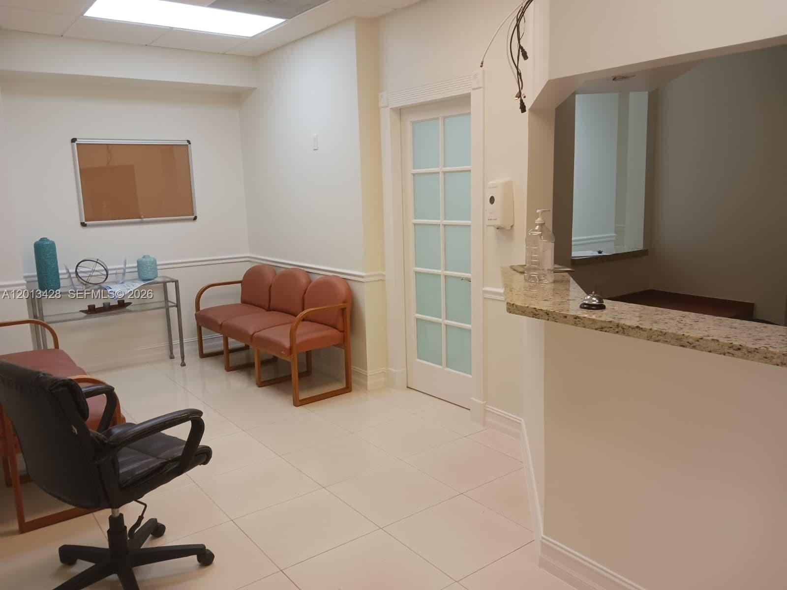 A waiting room features a reception desk, tiled floors, a glass-paneled door, and several chairs — 13155 SW 42nd St # 112, Miami FL 33175, MIAMI, FL