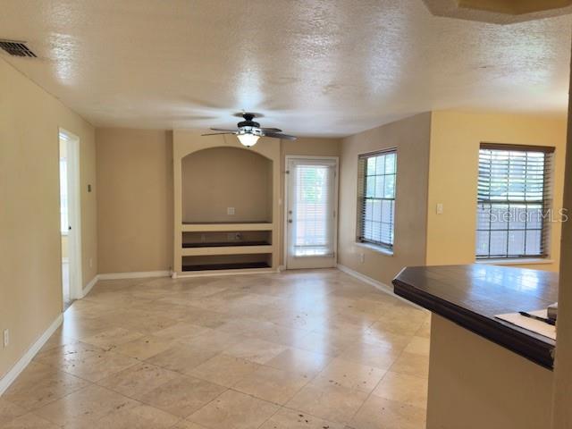 A living room with tile flooring, a built-in media niche, and a ceiling fan — 200 AFTON SQUARE UNIT 11-102, ALTAMONTE SPRINGS, FL