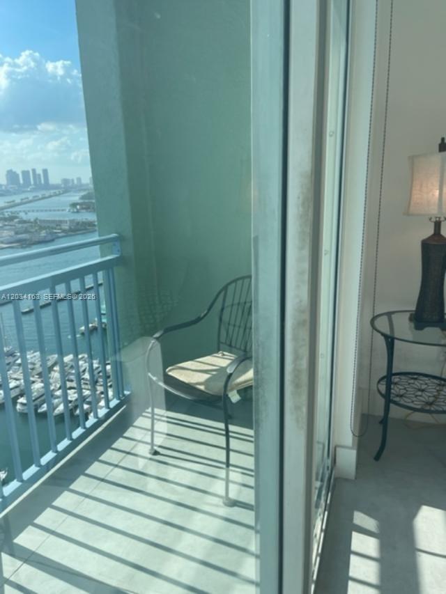 A balcony with a metal chair overlooks a marina and city skyline — 90 ALTON RD # 2908, Miami Beach FL 33139, MIAMI BEACH, FL