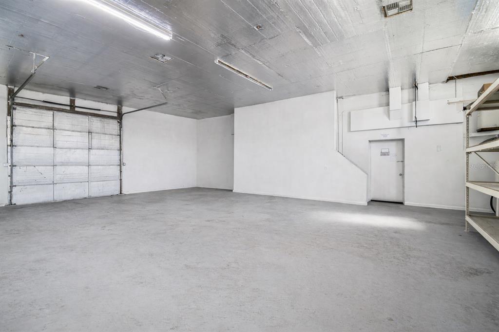 An empty garage space features a concrete floor, white walls, and a metal ceiling — 6010 WALL STREET, PORT RICHEY, FL
