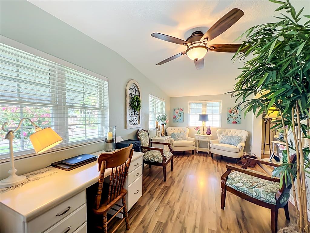 A home office with a desk, multiple chairs, wood-look flooring, and a ceiling fan — 1108 NASSAU CIRCLE, TAVARES, FL