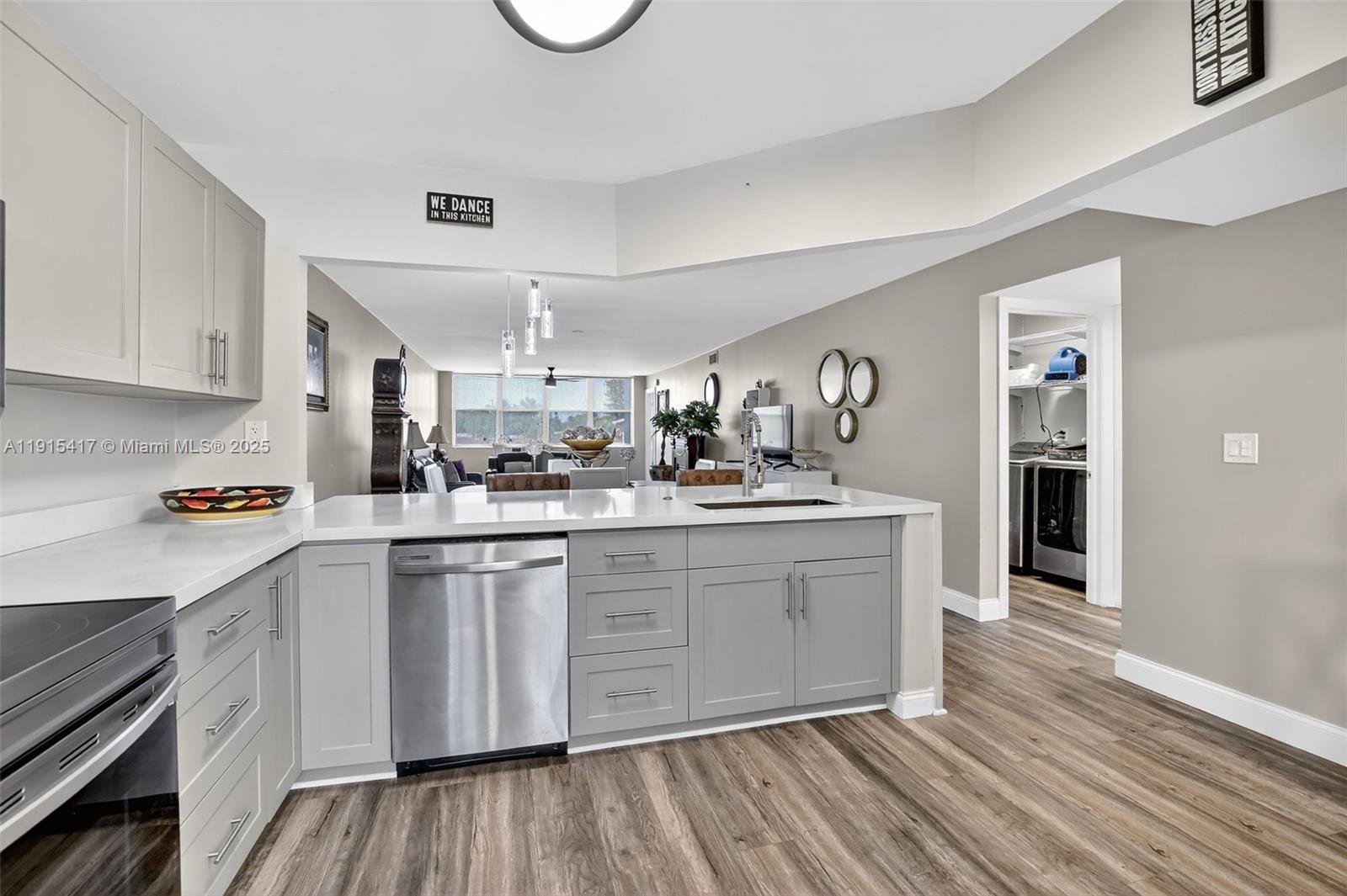 A kitchen features grey cabinets, stainless steel appliances, and a white countertop island — 2521 NW 104th Ave # 203, Sunrise FL 33322, SUNRISE, FL