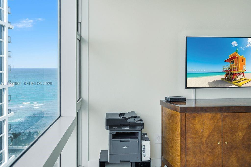 A room features a large window with an ocean view, a printer, and a television — 6801 Collins Ave # 1414, Miami Beach FL 33141, MIAMI BEACH, FL