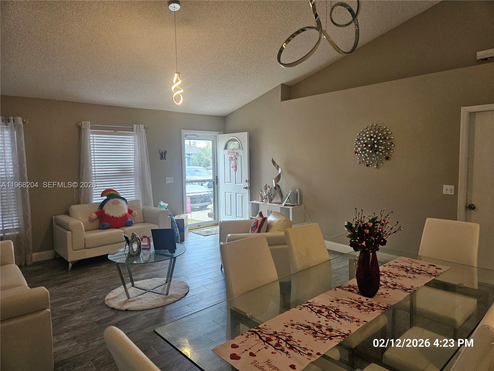 A living and dining area features tile flooring, vaulted ceilings, and modern furniture — 3046 Blaine Cir, Deltona FL 32738, DELTONA, FL