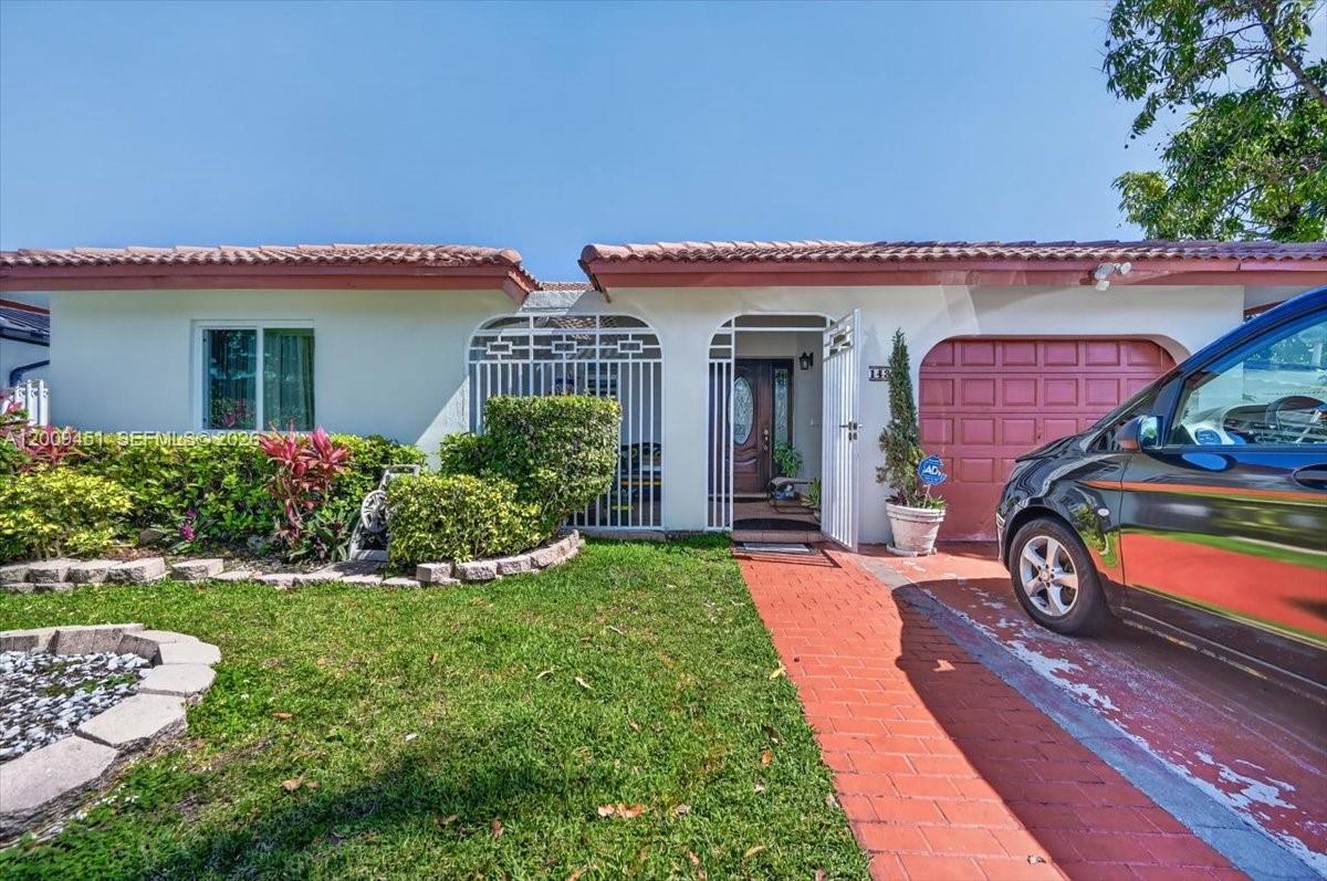 A single-story house features a red brick walkway, a garage, and a gated entryway — 14313 SW 100th Ln, Miami FL 33186, MIAMI, FL