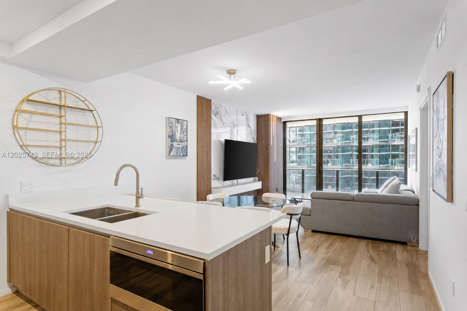 A wall-mounted television is centered on a marble panel flanked by vertical wood slats — 801 S Miami Ave # 3207, Miami FL 33130, MIAMI, FL