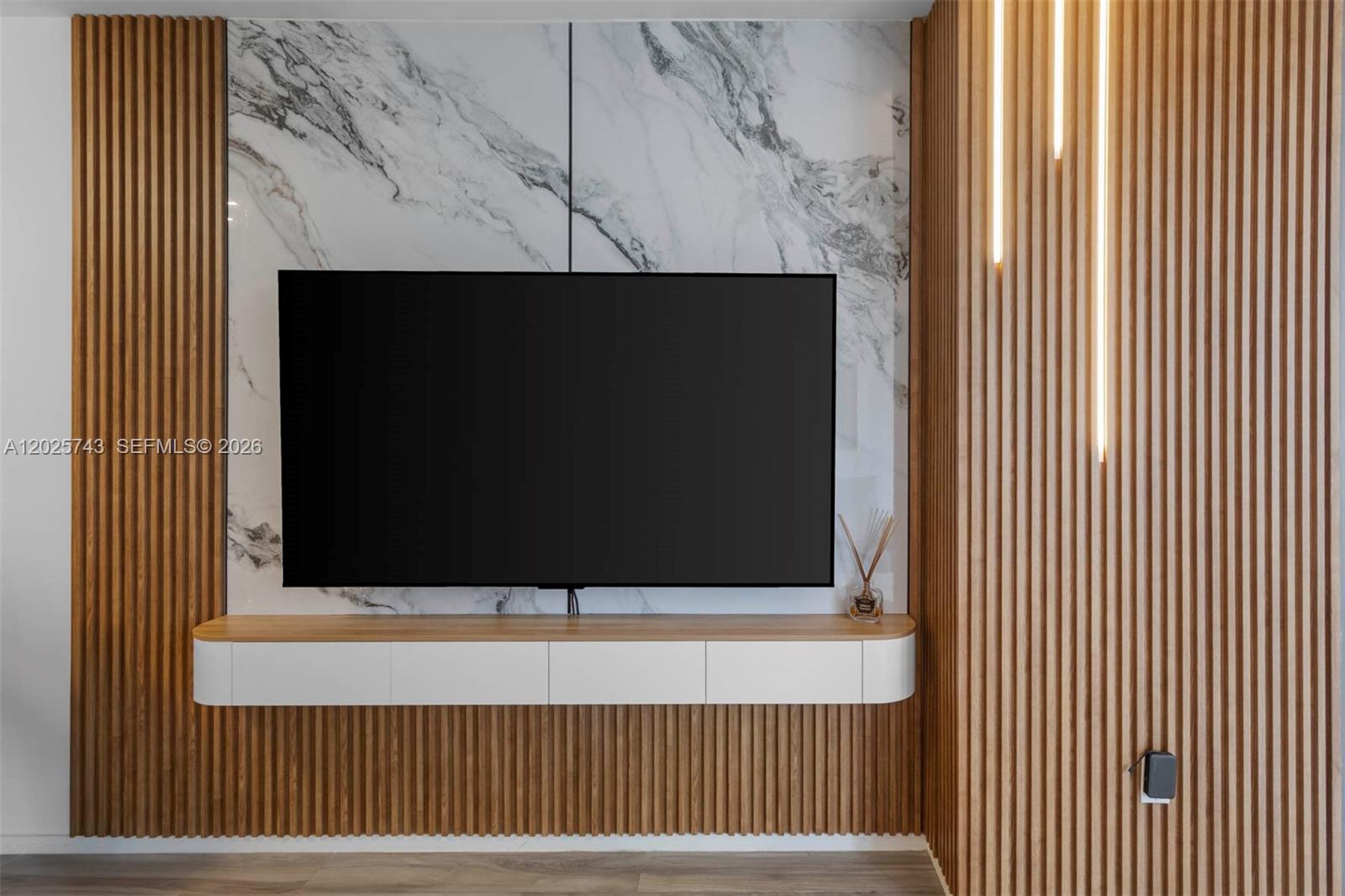 A modern kitchen features wood-toned cabinetry, white countertops, a central island, and gold fixtures — 801 S Miami Ave # 3207, Miami FL 33130, MIAMI, FL