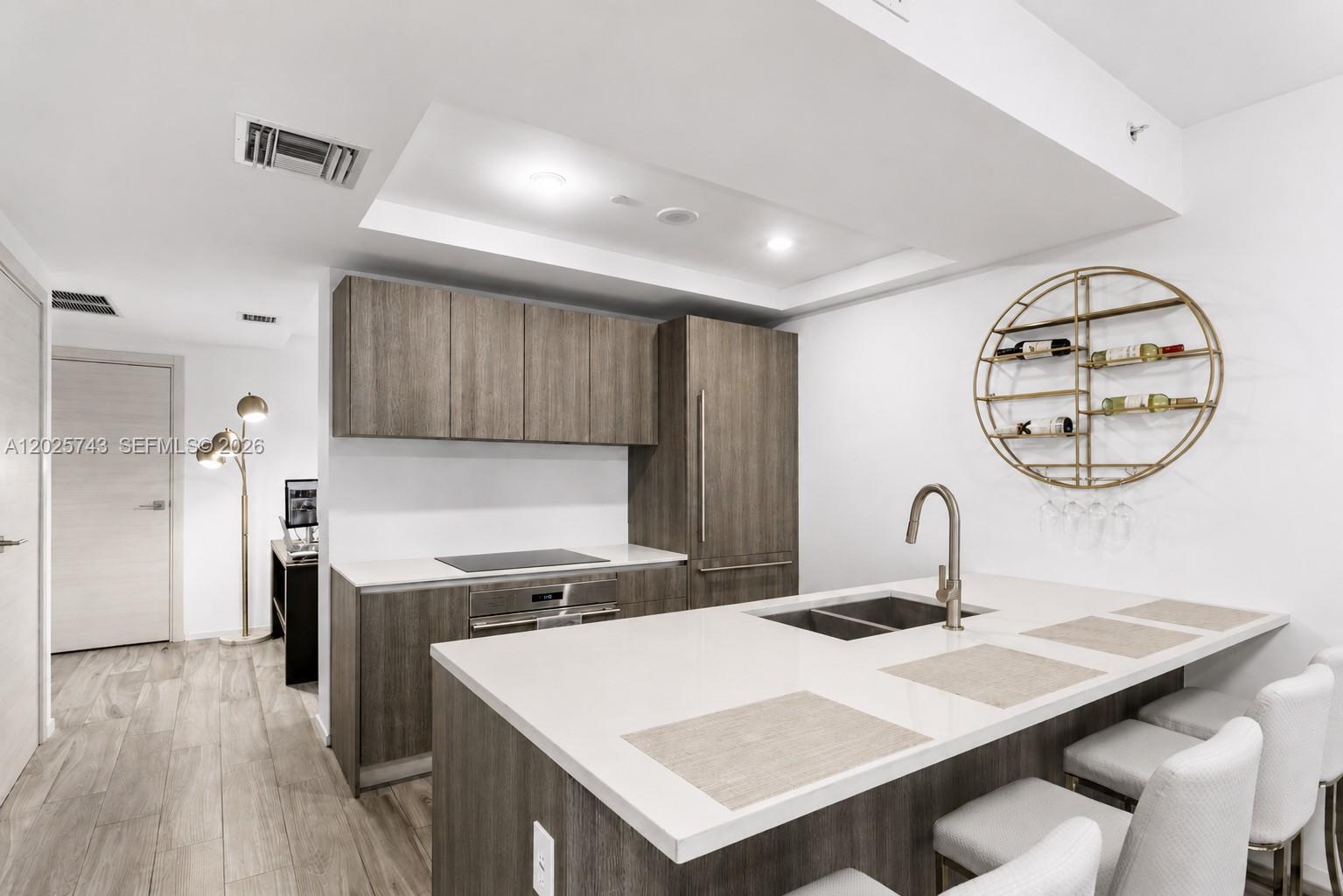 A modern bedroom features a white upholstered bed, pendant lighting, and light wood flooring — 801 S Miami Ave # 3207, Miami FL 33130, MIAMI, FL