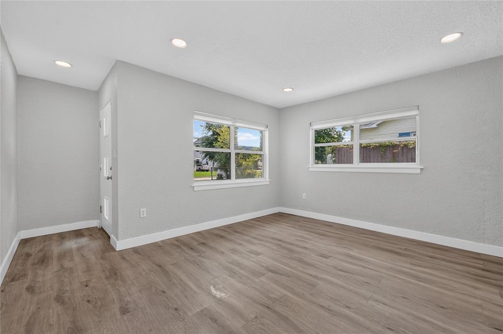 An empty room with light gray walls, wood-look flooring, recessed lighting, and two windows — 2510 BOYD AVENUE, ORLANDO, FL