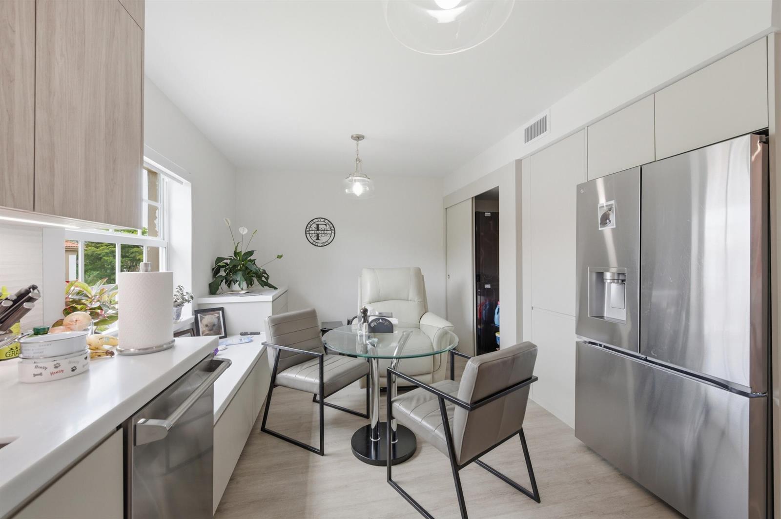 A kitchen dining area features a glass table, grey chairs, and stainless steel appliances — 7369 Orangewood Lane, Boca Raton FL 33433, BOCA RATON, FL