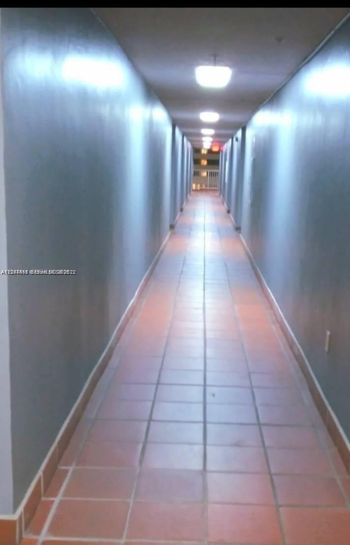 A long, narrow hallway with gray walls and light-colored tiled flooring — 104 SW 9th St # 304, Miami FL 33130, MIAMI, FL