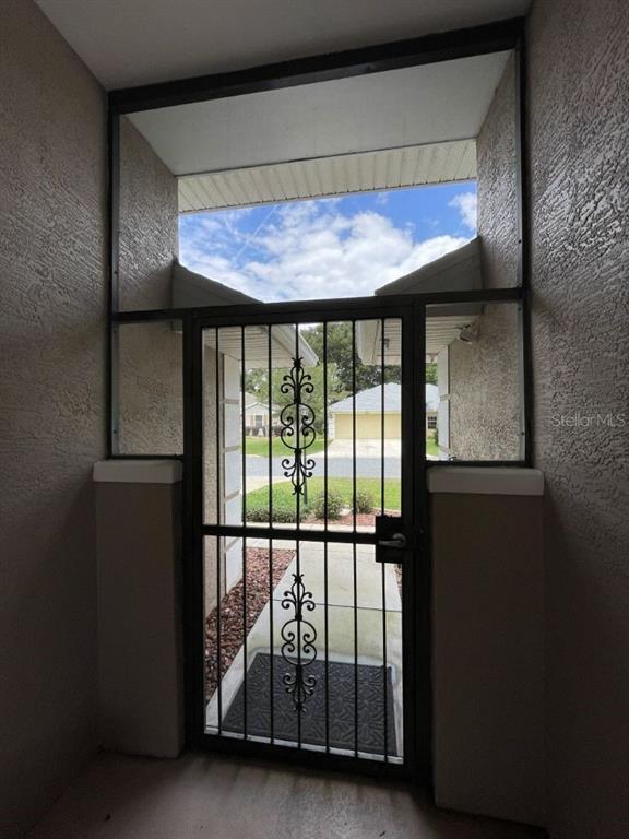 A view from a covered entryway looking out through a decorative metal security screen door — 5920 BAG PIPE PLACE, LEESBURG, FL