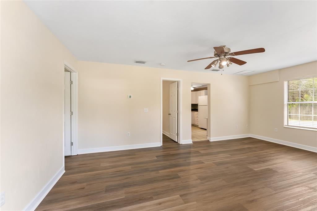 An empty room with light-colored walls, wood-look flooring, a ceiling fan, and two doorways — 18673 NW 252ND STREET, HIGH SPRINGS, FL
