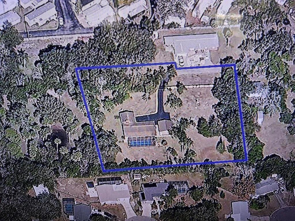 An aerial view shows a house with a pool inside a blue-outlined property boundary — 758 BUFFALO ROAD, TITUSVILLE, FL