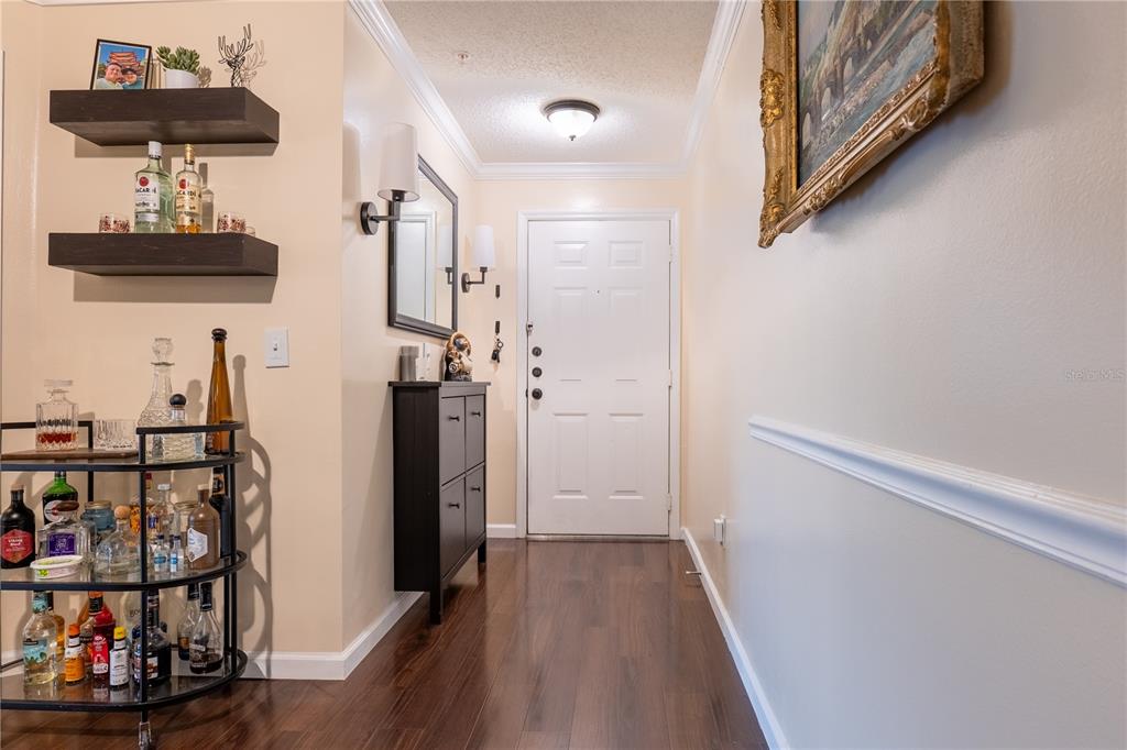 A dining area with a glass table and hutch opens into a living room with balcony — 1910 SUMMER CLUB DRIVE UNIT 212, OVIEDO, FL