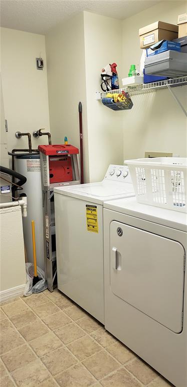 A laundry room features a washer, dryer, water heater, and wire shelving on the wall — 5678 SHEFFIELD GREENE CIR UNIT 76, SARASOTA, FL