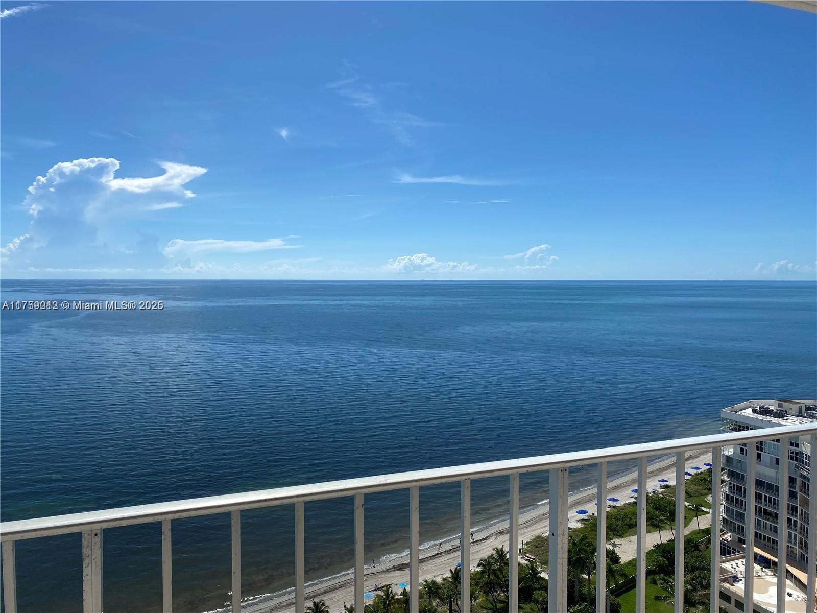 A high-angle view of the ocean and beach from a balcony with white railings — 881 Ocean Dr # 22F, Key Biscayne FL 33149, KEY BISCAYNE, FL