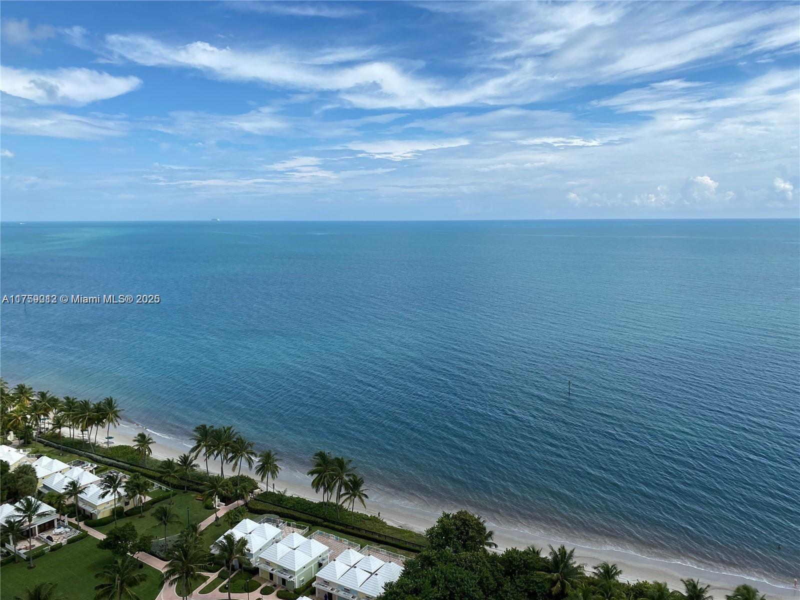 An elevated view of a sandy beach, palm trees, and coastal houses along the ocean — 881 Ocean Dr # 22F, Key Biscayne FL 33149, KEY BISCAYNE, FL
