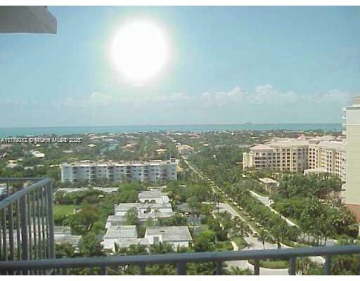 An elevated view from a balcony overlooking a coastal neighborhood with buildings and the ocean — 881 Ocean Dr # 22F, Key Biscayne FL 33149, KEY BISCAYNE, FL