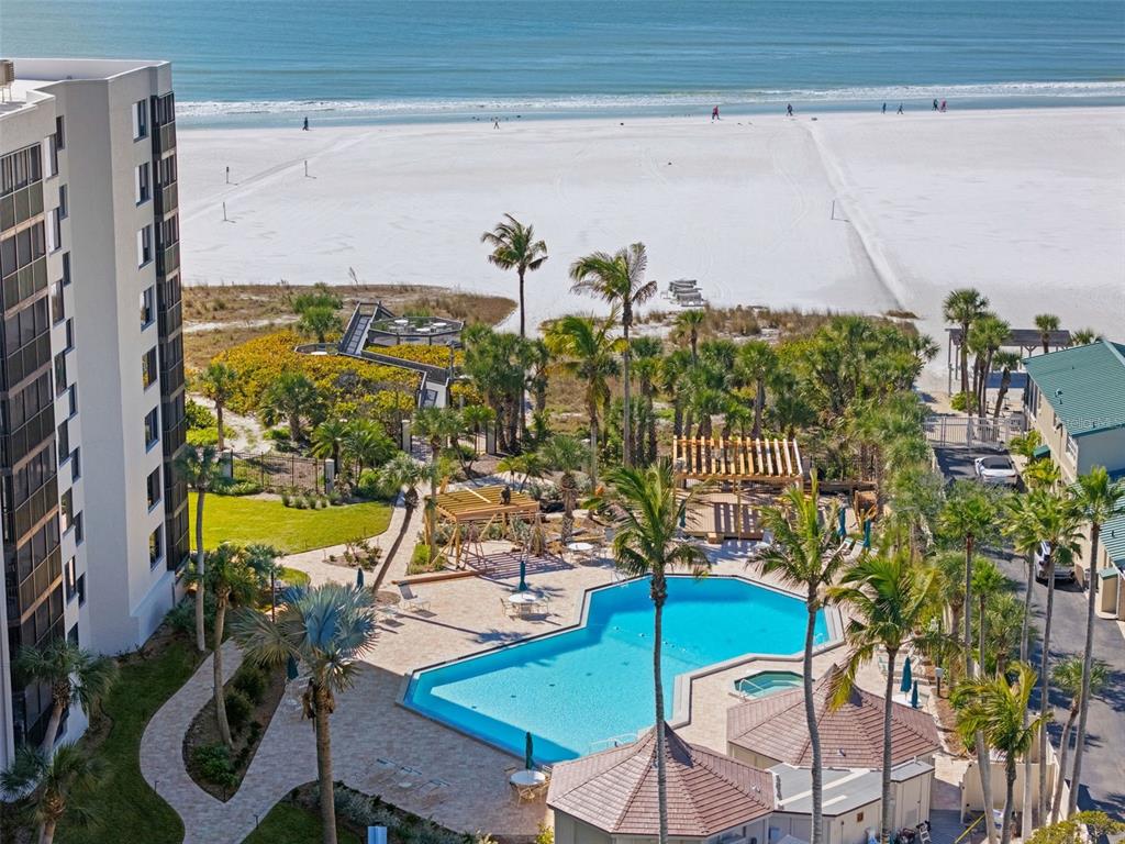 An aerial view of a swimming pool, palm trees, and a beach with white sand — 5880 MIDNIGHT PASS ROAD UNIT 605, SARASOTA, FL