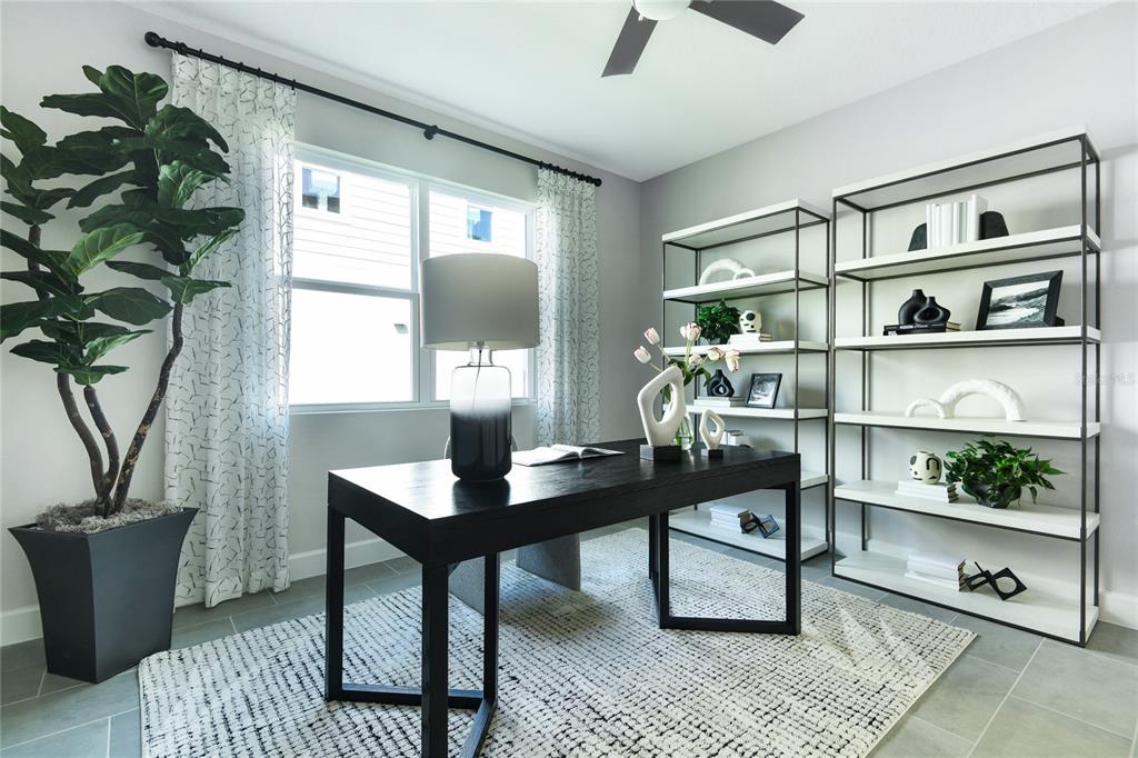 A home office features a dark desk, two open shelving units, and a large potted plant — 3445 MACCHI AVENUE, TAVARES, FL