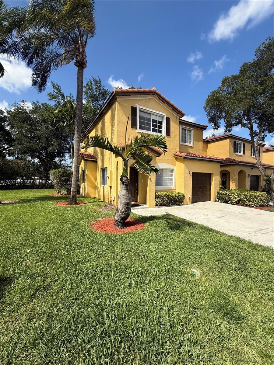 A two-story yellow stucco house with a brown tile roof and a palm tree — 1704 SW 101st Ter, Miramar FL 33025, MIRAMAR, FL
