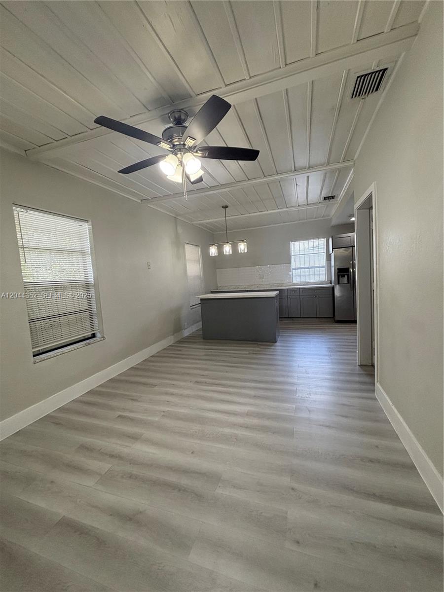 A kitchen and dining area feature gray cabinetry, a central island, and a plank ceiling — 5011 SW 5th St # 0, Miami FL 33134, MIAMI, FL