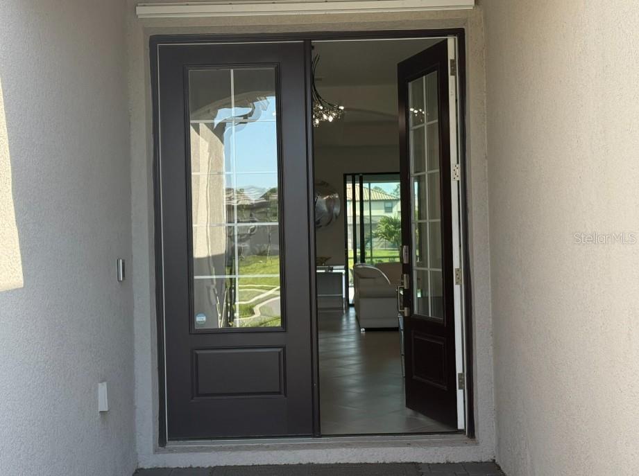 A single-story house with a stone-accented facade, a paved driveway, and a three-car garage — 4967 SEAFOAM TRAIL, BRADENTON, FL