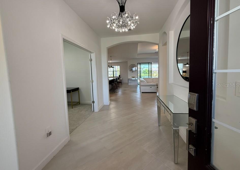A single-story house with a gray exterior, a three-car garage, and a paved driveway — 4967 SEAFOAM TRAIL, BRADENTON, FL
