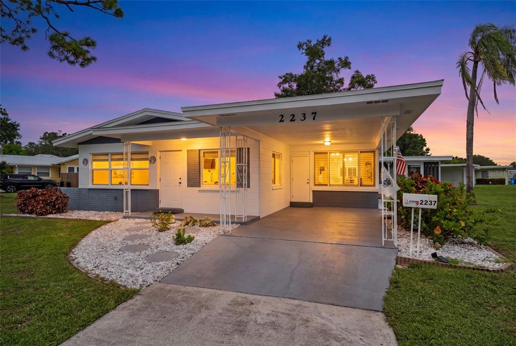 A single-story house with a carport, white exterior walls, and a gravel front yard — 2237 2ND AVENUE E, BRADENTON, FL