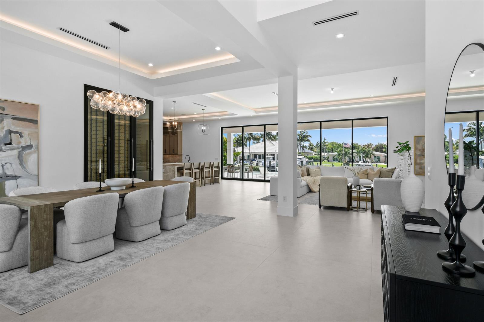 An open-concept living and dining area features white walls, tile floors, and large glass doors — 2408 Azure Circle, Palm Beach Gardens FL 33410, PALM BEACH GARDENS, FL