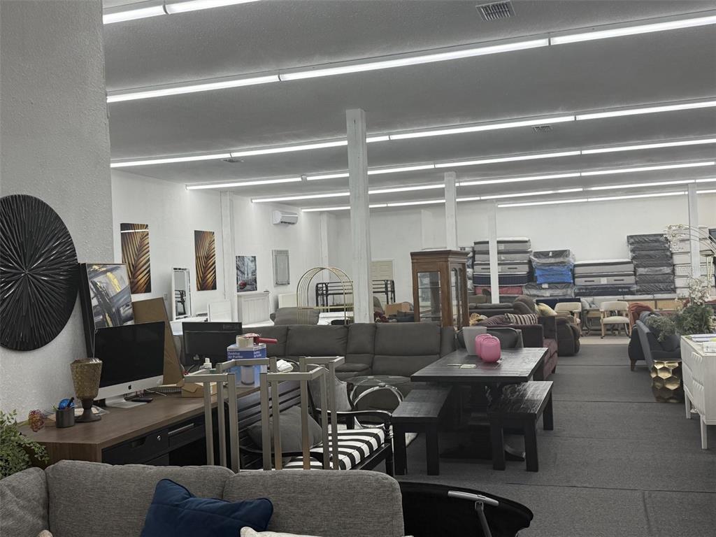 A furniture showroom features rows of sofas, dining sets, and stacked mattresses under fluorescent lighting — 2698 S ORANGE BLOSSOM TRAIL, ORLANDO, FL