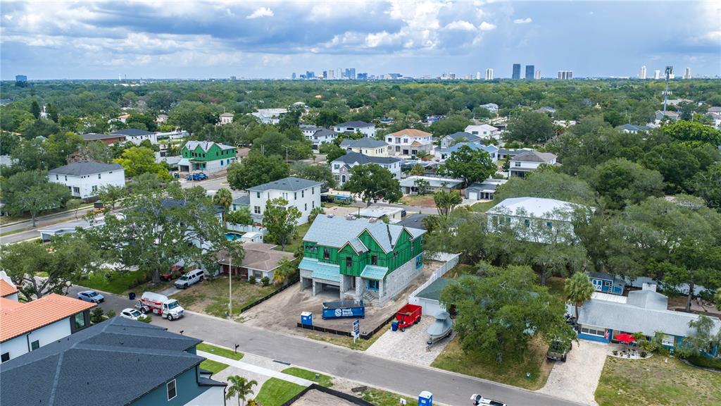 An aerial view shows a residential neighborhood featuring a house under construction with green sheathing — 3606 S BELCHER DRIVE, TAMPA, FL