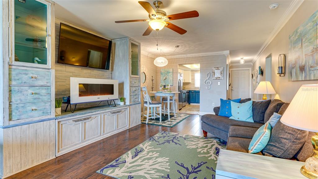 A living room features a built-in entertainment center with a fireplace, sectional sofa, and dining area — 3276 LAKE BAYSHORE DRIVE N UNIT O-517, BRADENTON, FL