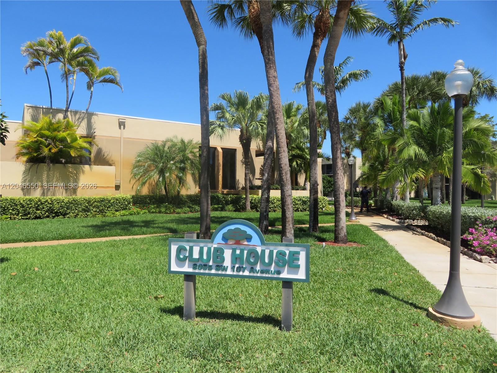 A sign for a clubhouse stands on a grassy lawn in front of a building — 8075 SW 107th Ave # 305, Miami FL 33173, MIAMI, FL