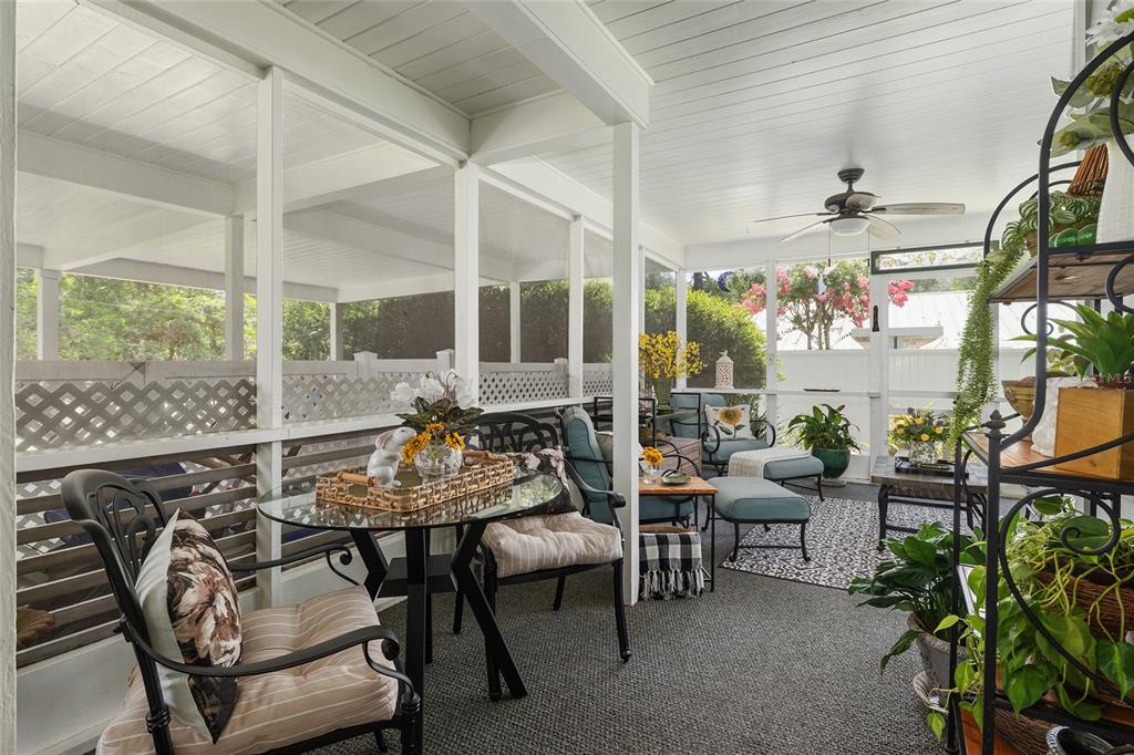 A screened-in porch features a glass-top table, patio furniture, and a ceiling fan — 1807 SW 36TH PLACE, GAINESVILLE, FL