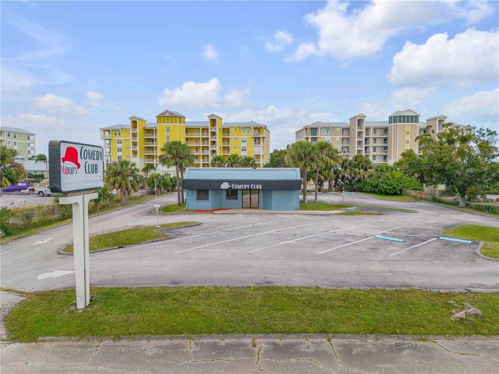 An exterior view of a comedy club building with a parking lot and surrounding apartments — 109 N CAUSEWAY, NEW SMYRNA BEACH, FL